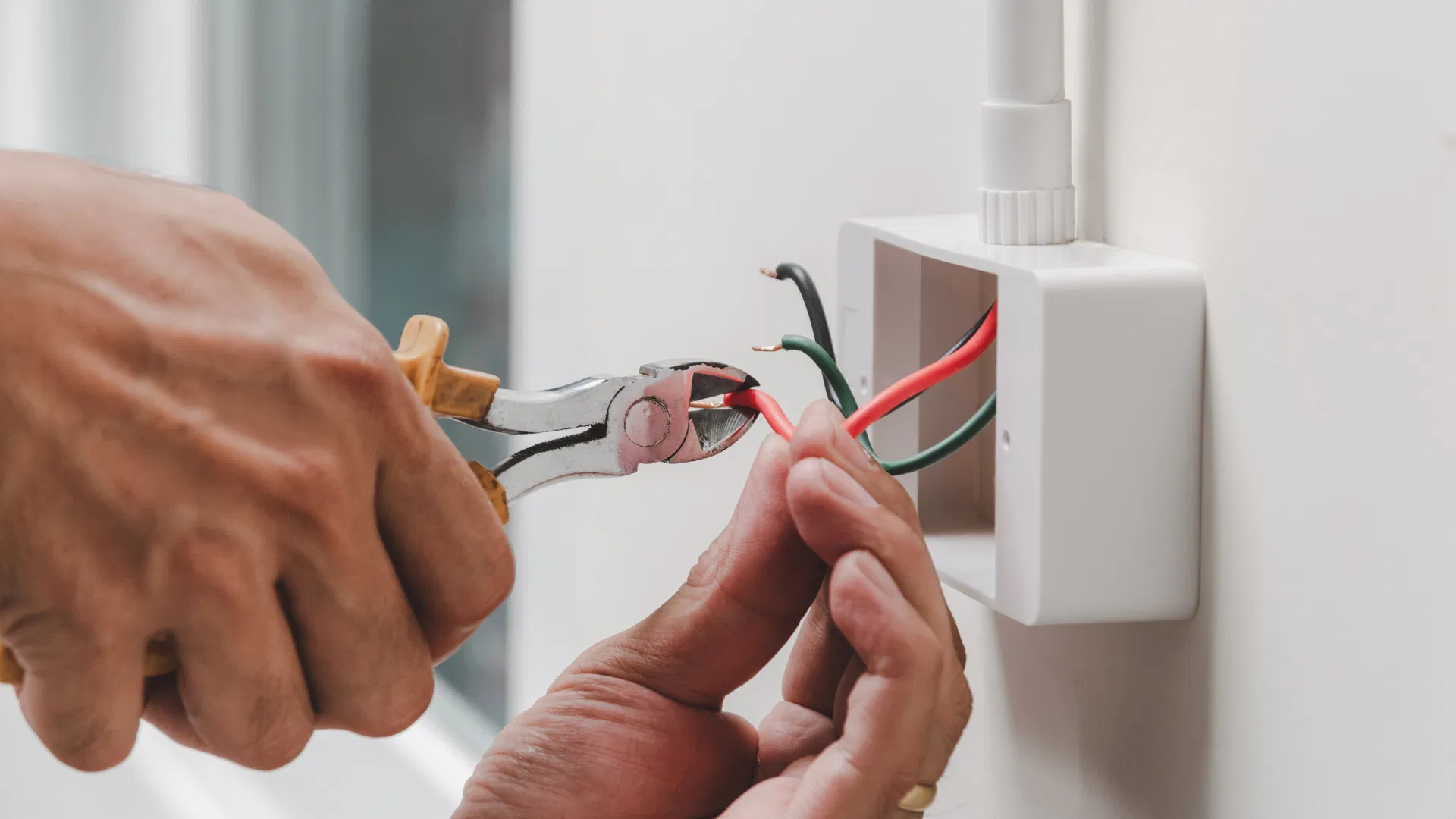 Licensed electrician carefully preparing wires for a safe residential installation